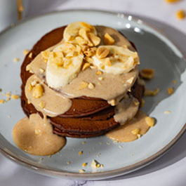 Chocolate pancakes with banana and peanut sauce