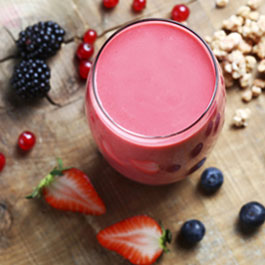 Smoothie de frutas rojas y plátano con granola y leche de soja