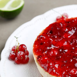 Pastel de queso de lima y cardamomo con grosellas rojas