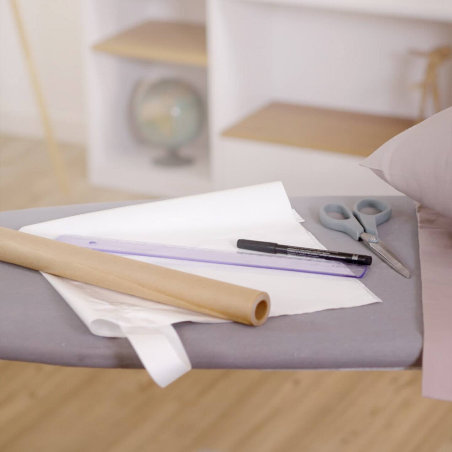 A table with a sewing machine, scissors, and paper