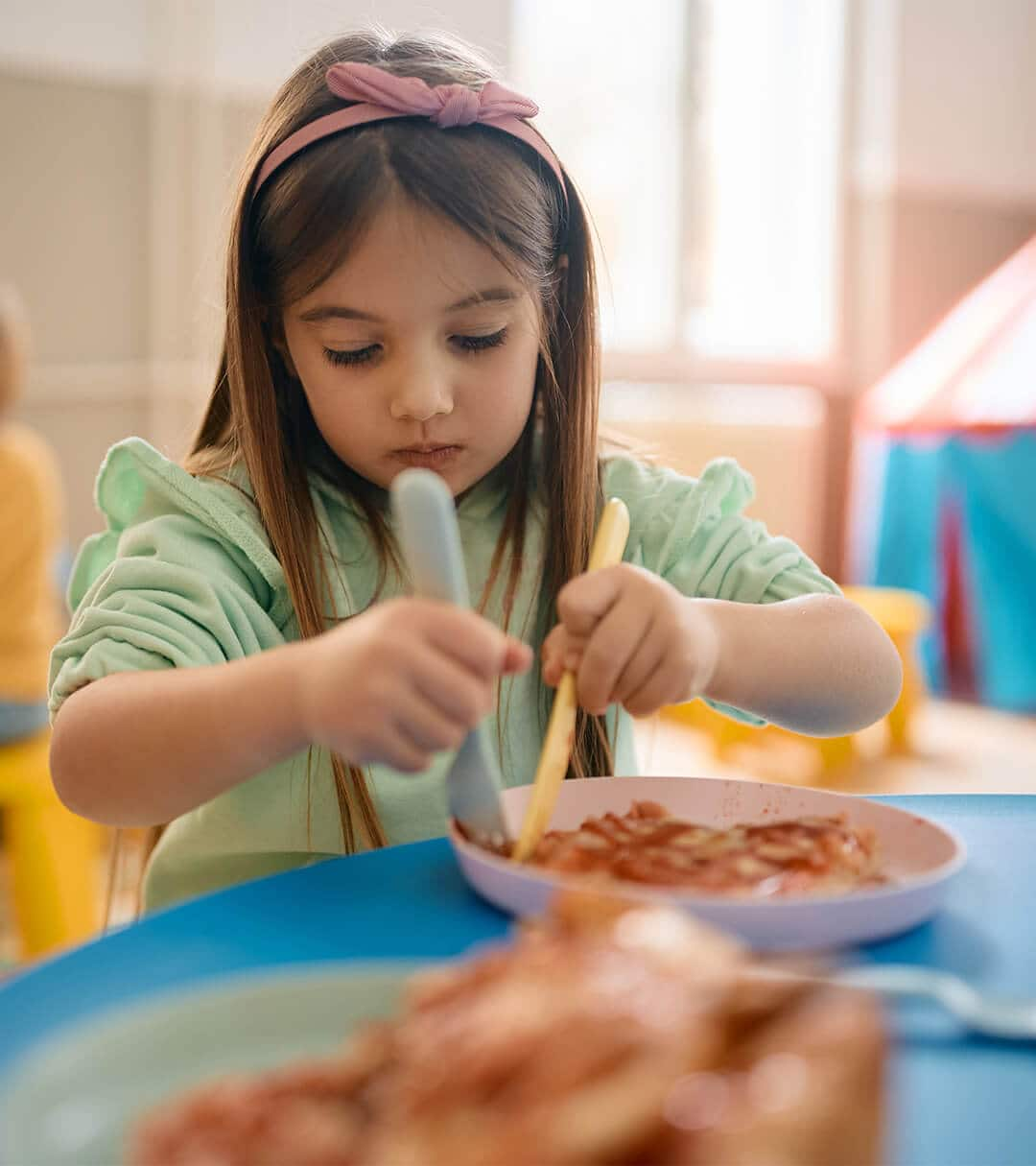 Young girl eating at the table 