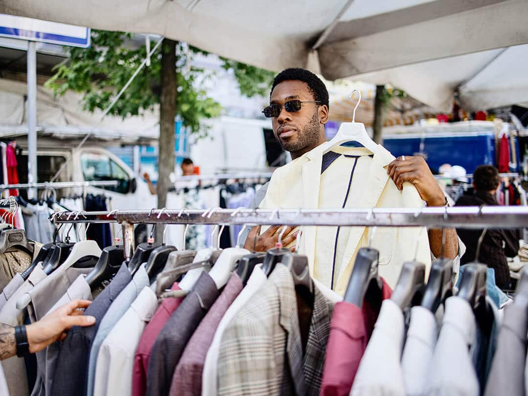 Man with sunglasses man holds up a white suit