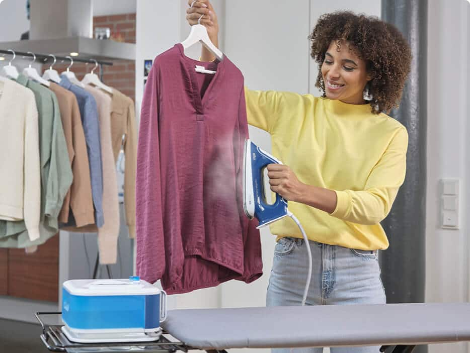 Woman steaming a shirt vertically with a Braun CareStyle steam iron