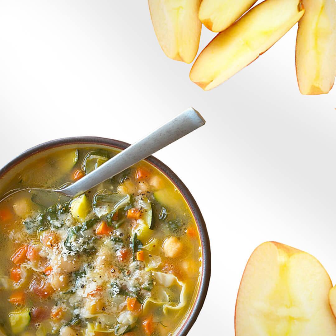 Soup with salt on top in a bowl with apple slices aside