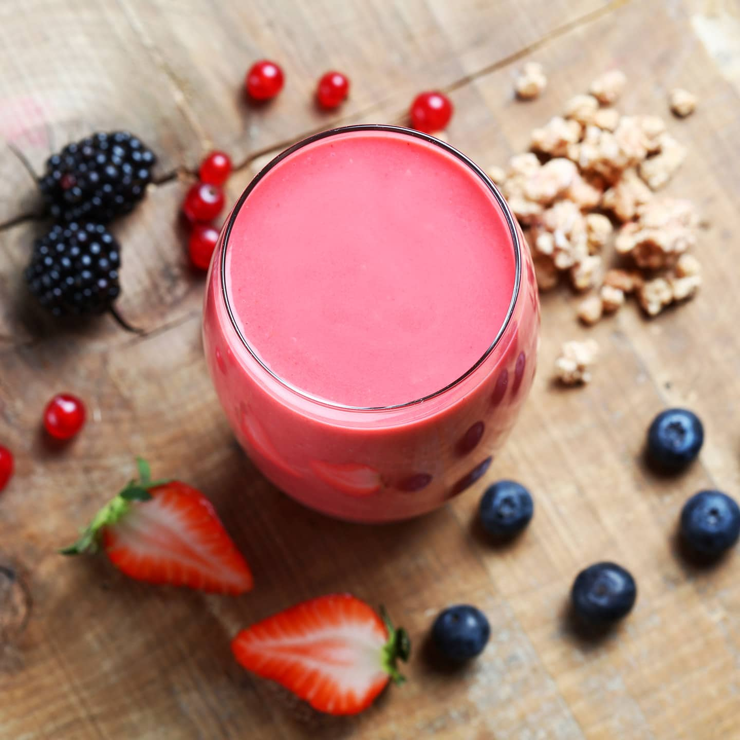 Red fruit-banana smoothie with granola and soy milk